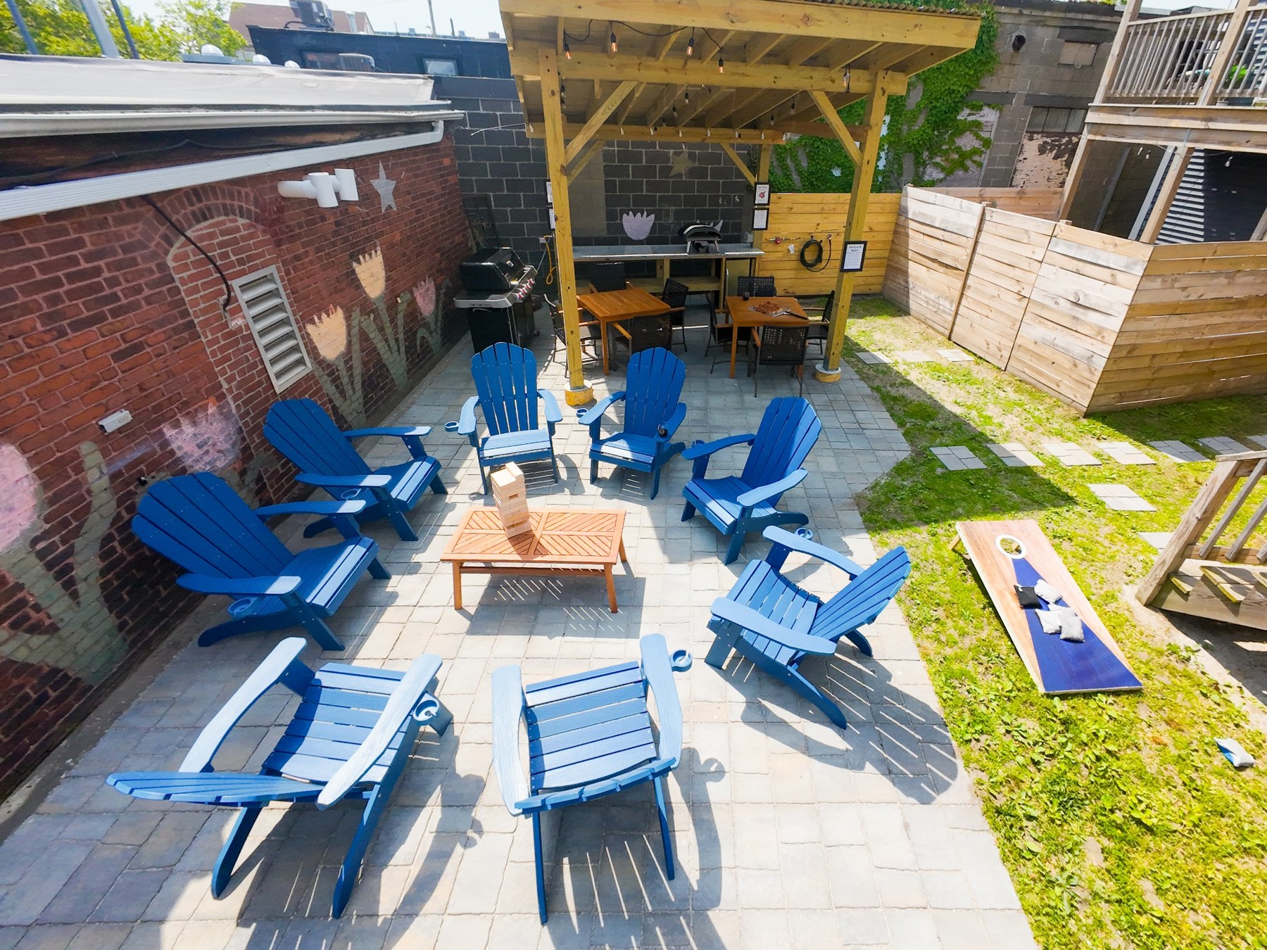 Blue Adirondack chairs and lawn games in Dean Street’s shared backyard